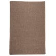 Colonial Mills Courtyard Cocoa braided rug in warm brown tones, enhancing a cozy indoor space. Ideal for rustic or traditional decor.