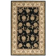 Elegant black Nourison Nourison 2000 2022 rug, hand-tufted, featuring intricate patterns in ivory and gold, set on a hardwood floor.