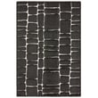 Jaipur Living Tazeka Arthes Black TAZ-02 rug with intricate geometric patterns in black and cream, shown on a hardwood floor setting.
