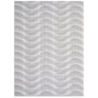 Chilewich Woven Arc Sesame rug, beige and tan hues, displayed on a wooden floor, showcasing intricate woven patterns.