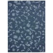 Chilewich Woven Botanic Indigo rug featuring a rich blend of blue and beige tones, showcasing intricate weaving in a stylish modern room setting.