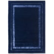 Laura Ashley Redbrook Midnight rug, hand-tufted, features intricate patterns in rich blue hues, enhancing a cozy living room setting.