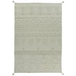 The image showcases a Lorena Canals Tribu Olive, Soil Brown hand-tufted rug with a tribal pattern, ideal for adding warmth to any room.