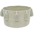 Lorena Canals New Tassels Basket Olive, hand-made with earthy tones, displayed in a cozy interior setting with a warm ambiance.